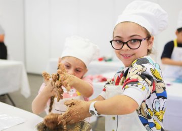 Image of children cooking at a mini chef class